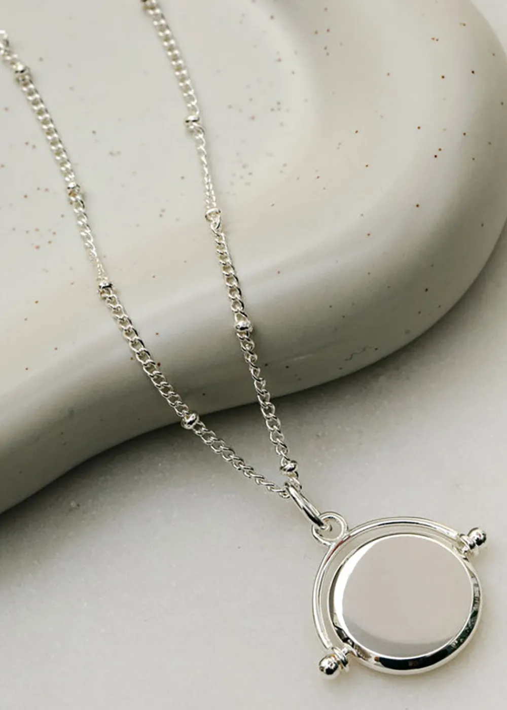 faceted_disc_spinner_neck_4.webp Orelia Faceted Disc Spinner Necklace - Silver | Necklaces